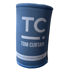 Blue stubby holder in blue with the Tom Curtain logo on it (TC with a line and dot)