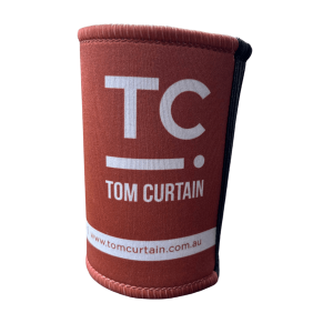 Burnt orange stubby holder in blue with the Tom Curtain logo on it (TC with a line and dot)