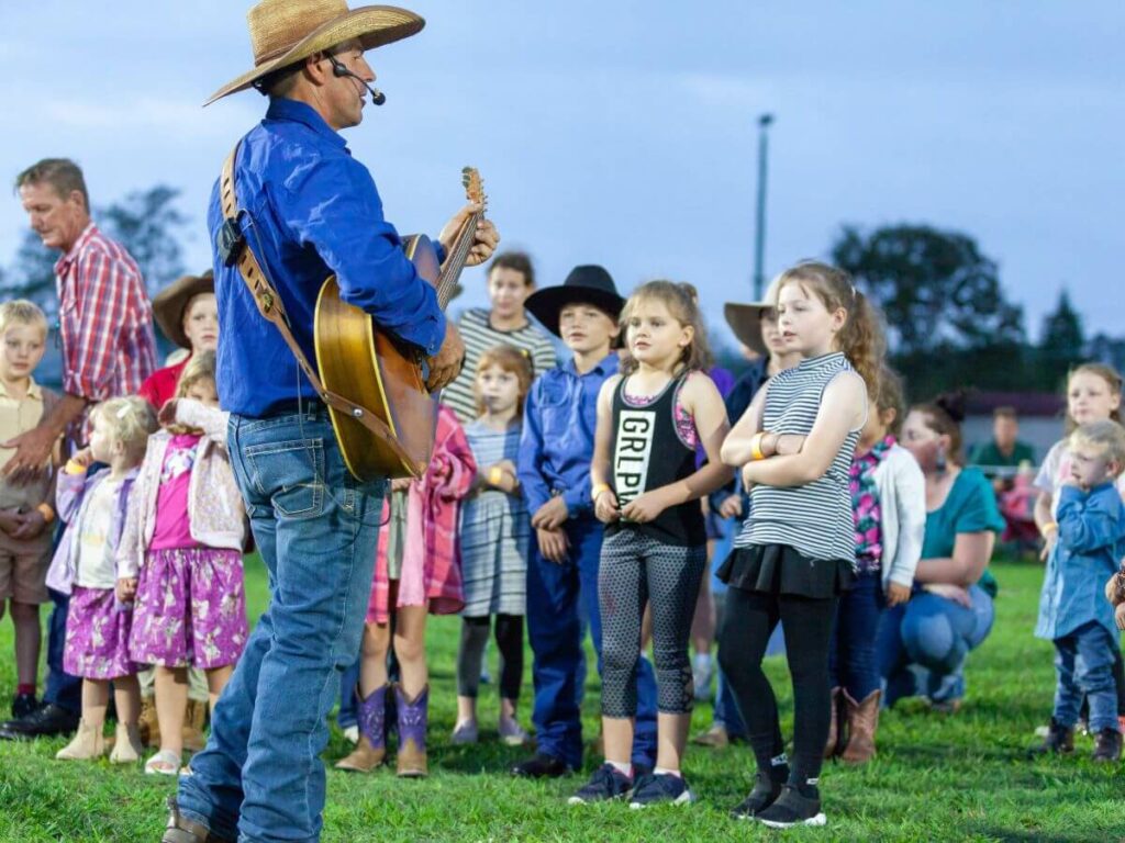 Tom singing Speak Up with kids on tour